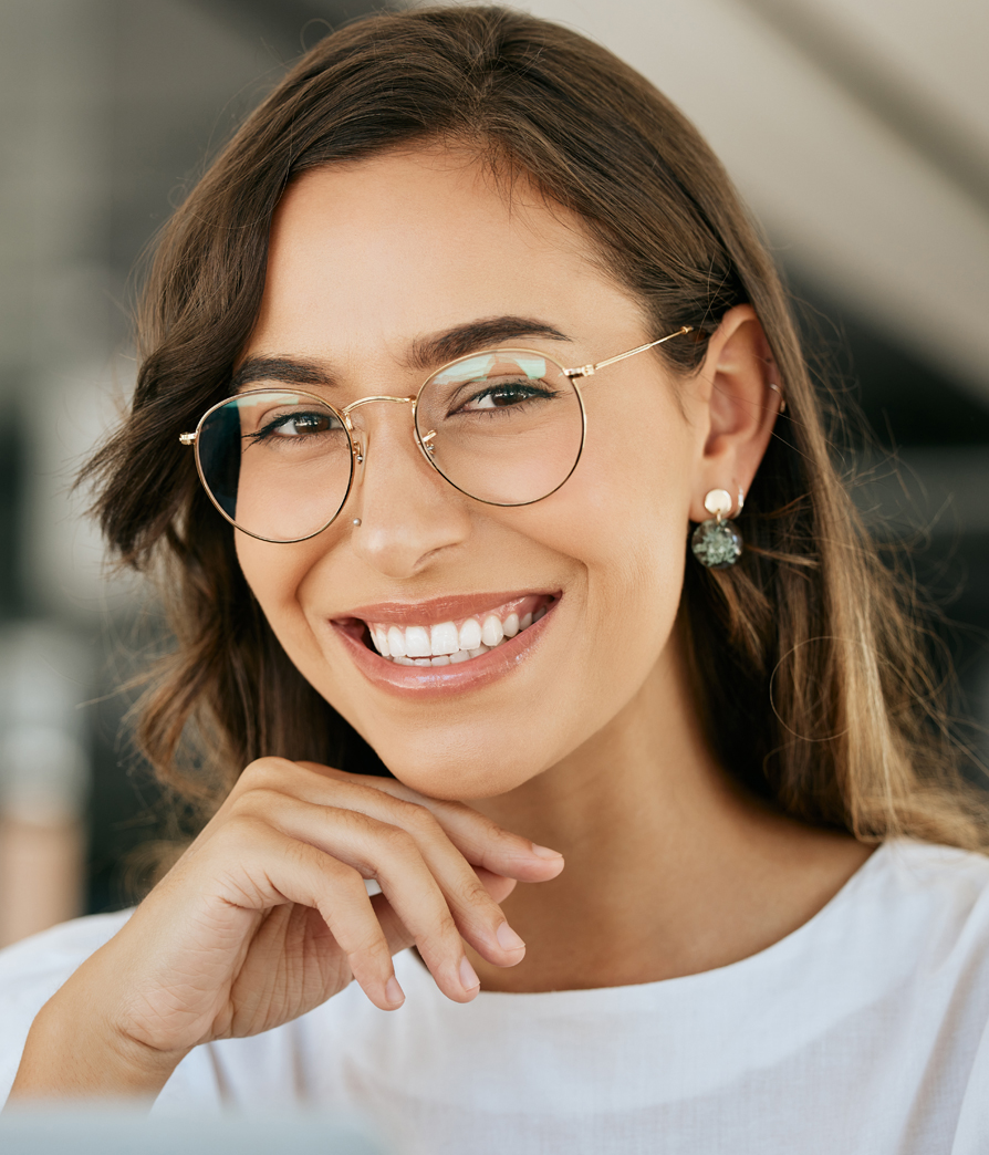 Female model wearing glasses smiling at the camera, Facial Trauma Surgery in NYC